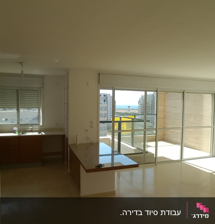 מטבח ריק עם חלונות גדולים ומרפסת